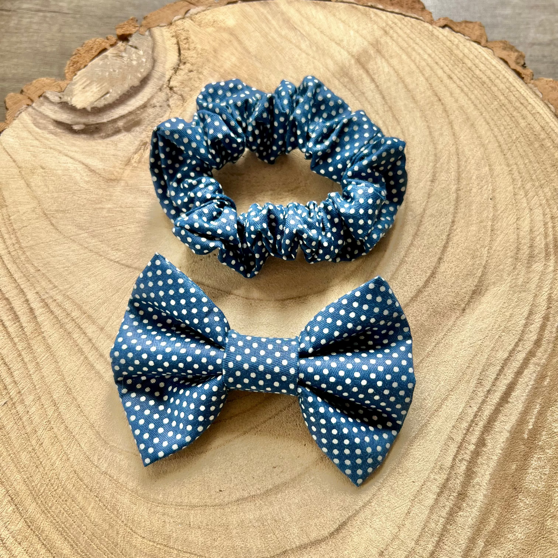 Blue polka dot bow tie and scrunchie on a wooden surface