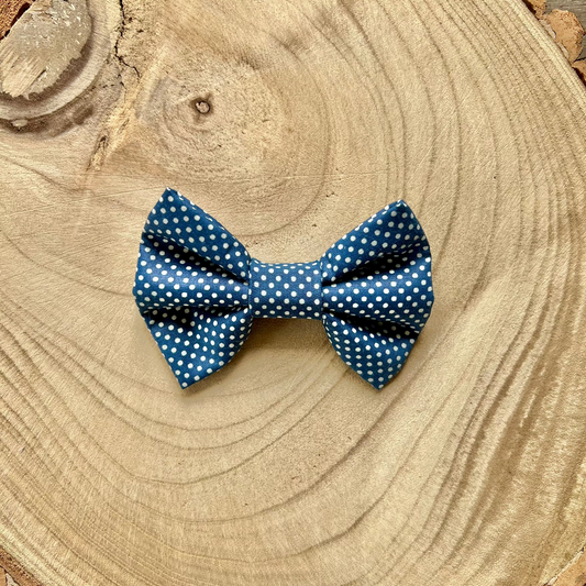 Blue polka dot bow tie on a wooden surface