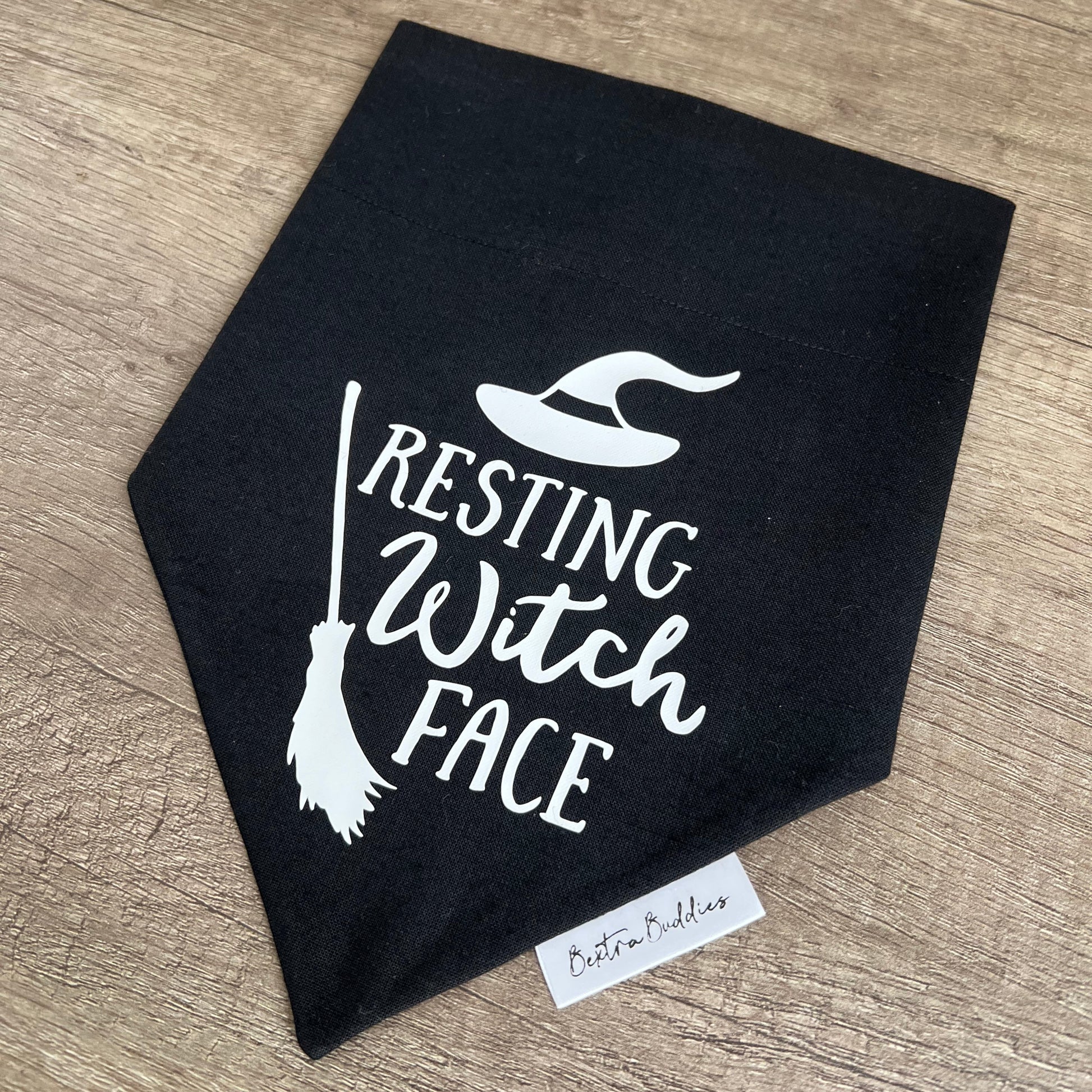 Black bandana with 'Resting Witch Face' text and broom design on a wooden surface